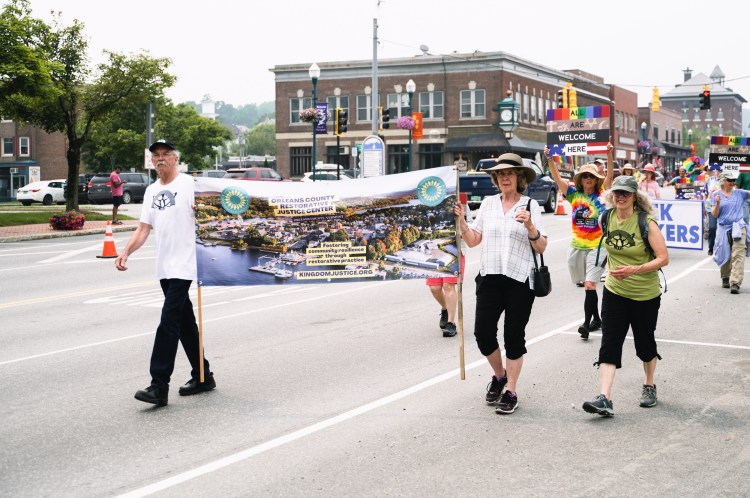 Two volunteers carrying Orleans County Restorative Justice Banner