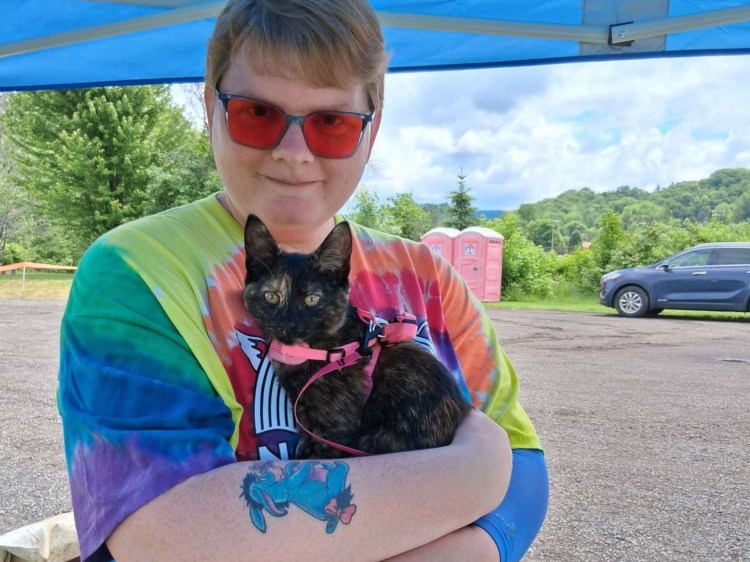 Person in tie die shirt with tortie kitten