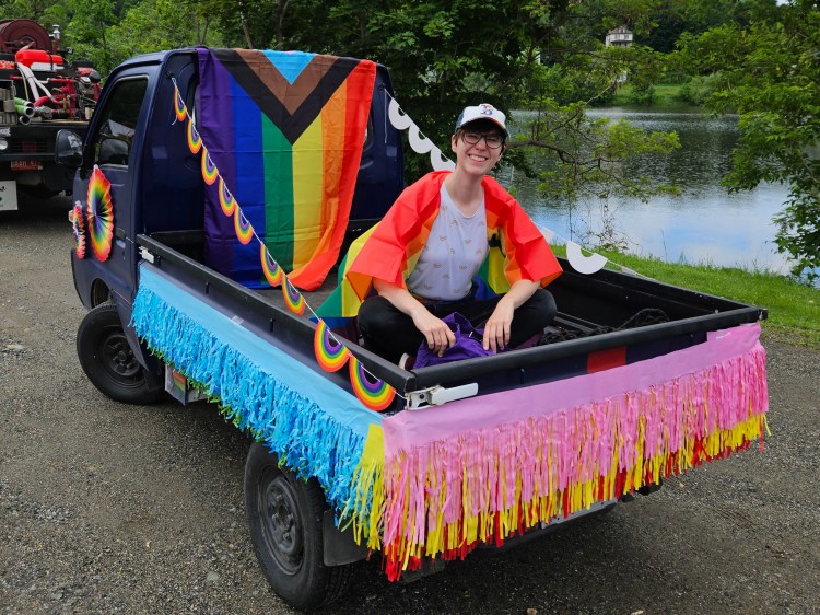 Smiling person sitting in bed of truck