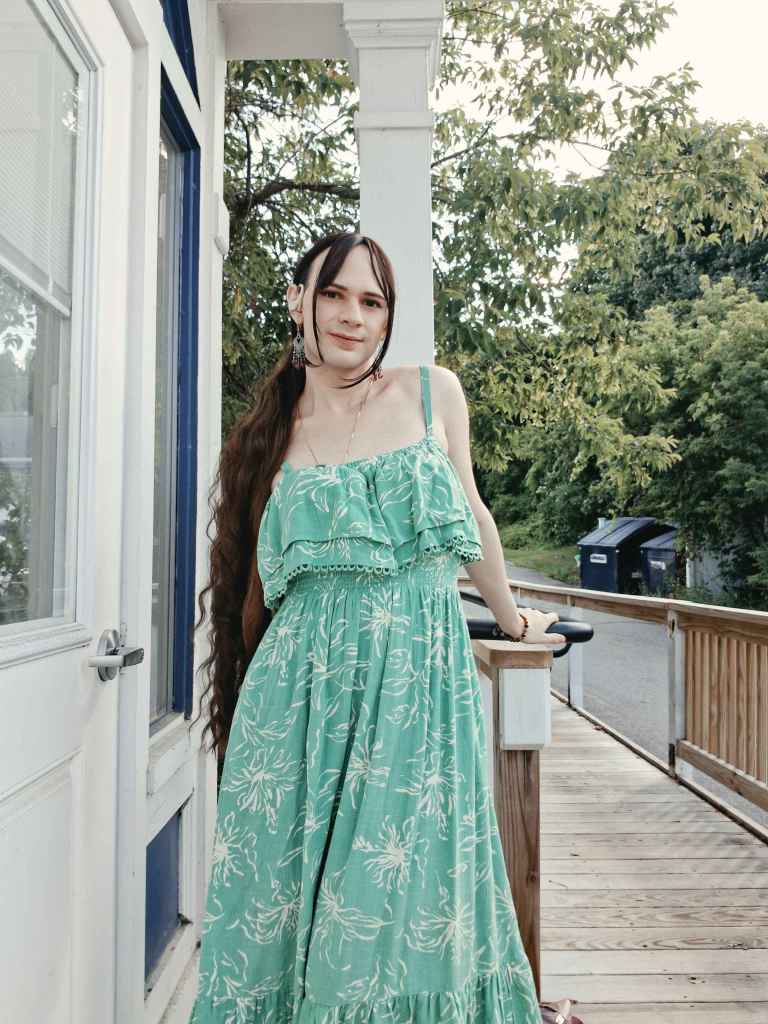 Picture of OT member Kiki standing on a porch in a light green dress